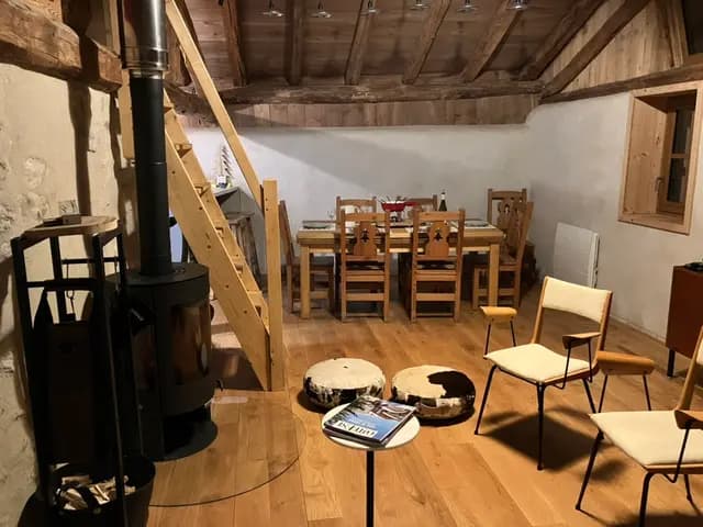 Le grand séjour sous charpente, poêle à bois et table dressée